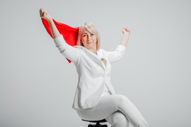 a woman in a white suit with a red scarf on a white background