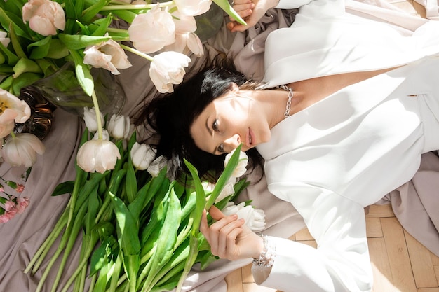 Woman in white suit with white tulips