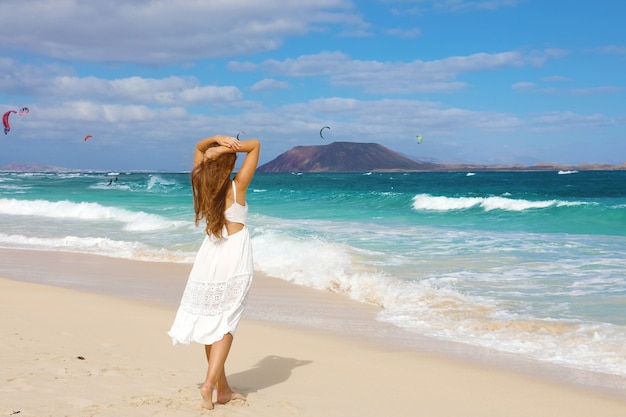 Woman in white sundress walking on Corralejo, Fuerteventura