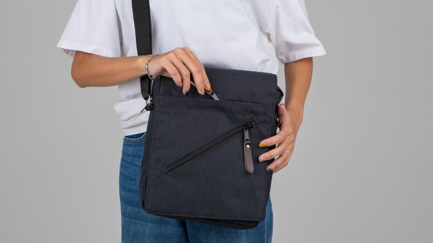 Woman in white t-shirt carry the casual bag on shoulder with active and easy gesture.