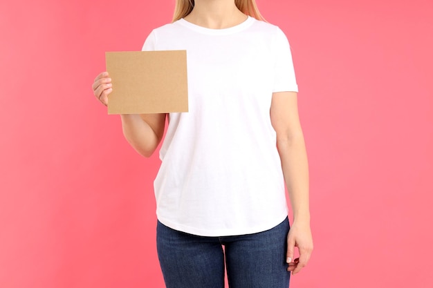 분홍색 배경에 텍스트를 위한 공간이 있는 흰색 티셔츠를 입은 여성