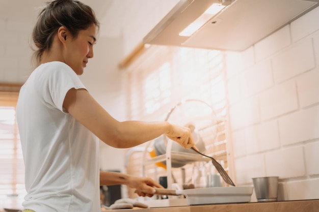 Photo woman in white tshirt cooking in the kitchen making lunch