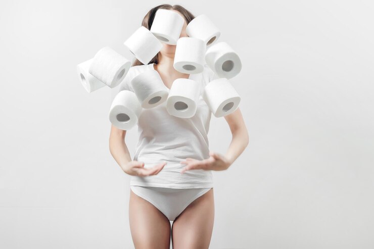 Photo 白い t シャツを着た女性が、白い背景に手にトイレット ペーパーの芯を投げる