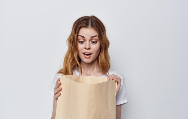 Woman in a white tshirt with a package in her hands shopping High quality photo