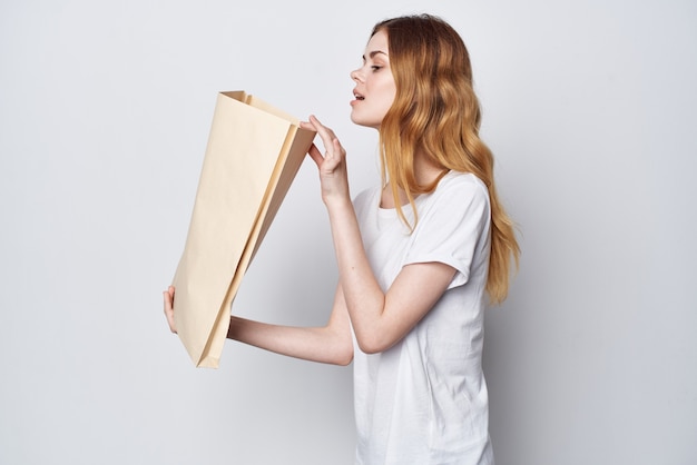 Woman in a white tshirt with a package in her hands\
shopping