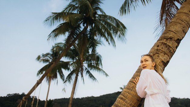 Woman in a white tunic shirt on beach near stormy sea tilted p