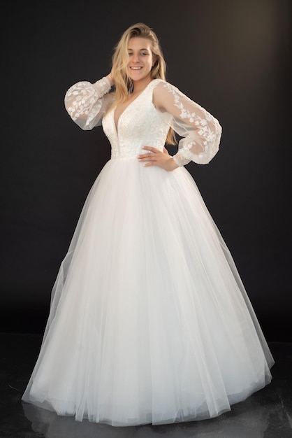 A woman in a white wedding dress with a long sleeved top.