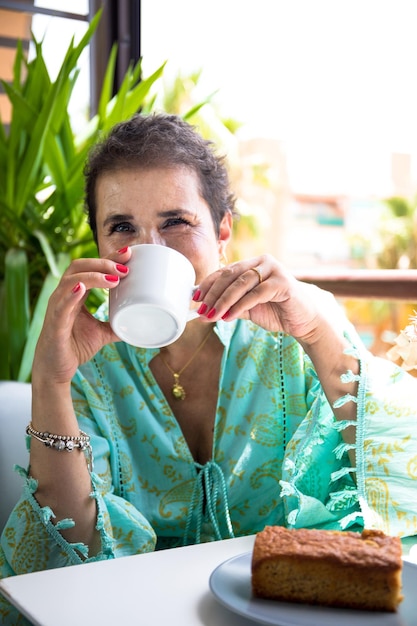 癌を克服した女性がテラスでコーヒーを飲んでいます。