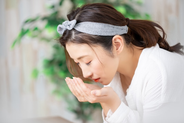 家でスキンケアをする女性