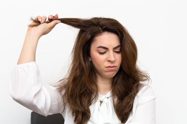 Photo woman who pulls a lock of hair concept of trichotillomania a compulsive psychological disorder