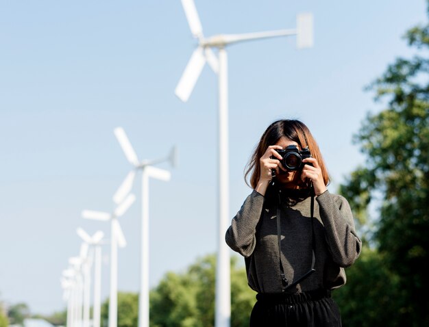 Женщина на поле ветряной мельницы с фотографией