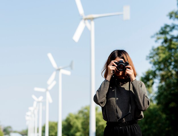 Woman at windmill field taking a photo