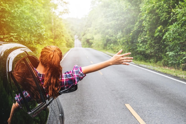 Woman in window of car on road