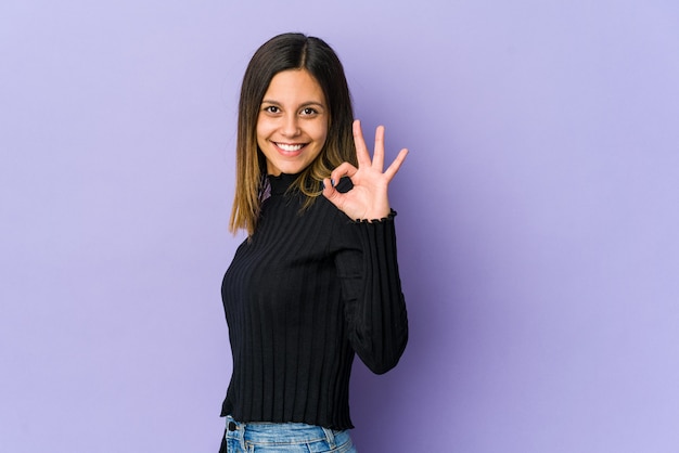 Woman winks an eye and holds okay sign