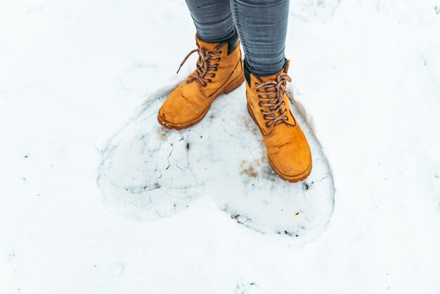 雪の上の女性の冬のブーツをクローズ アップ