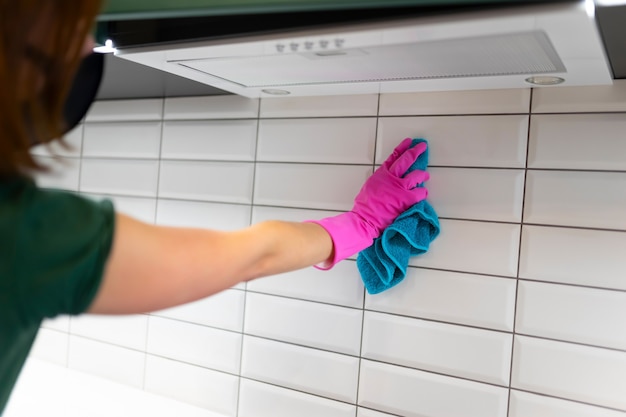 Woman wipes tiles in the kitchen