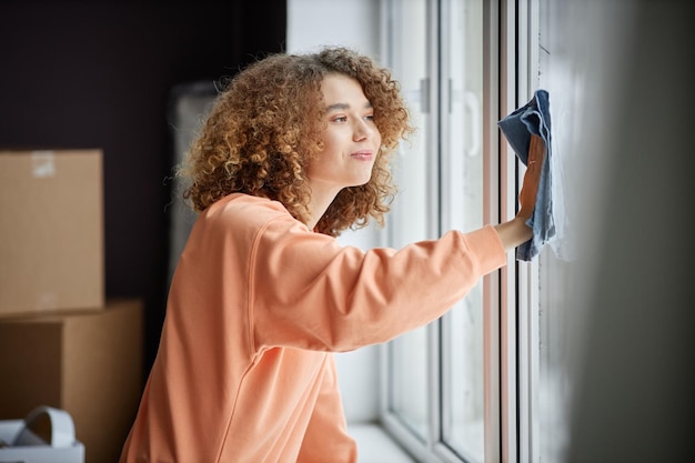 Woman wiping dust from window