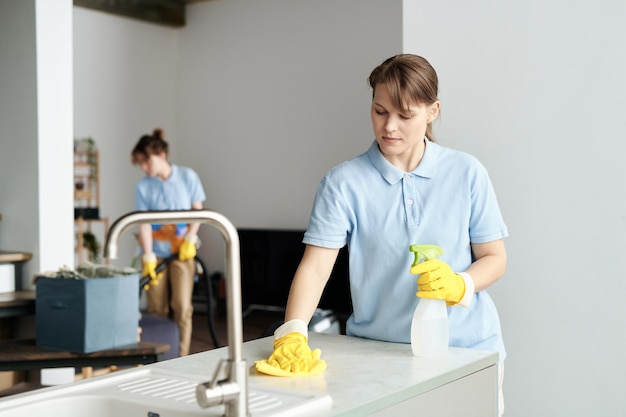 Woman wiping dust with her colleague