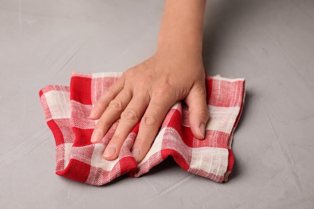 Woman wiping stone surface with kitchen towel closeup