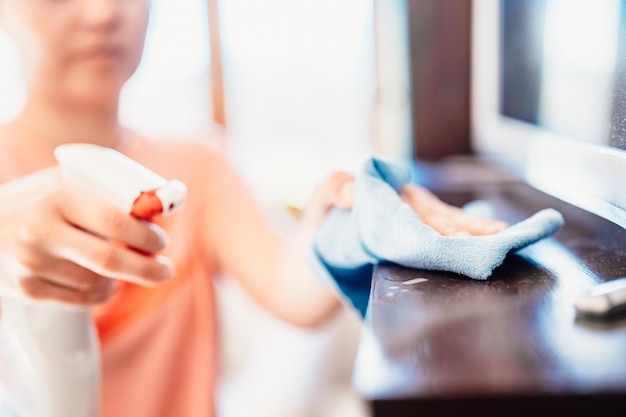 Woman wiping the table with microfiber cloth Closeup detail Housekeeping concept