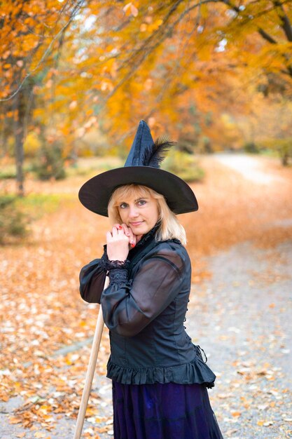 A woman in a witch suit in a dense forest on a ritual