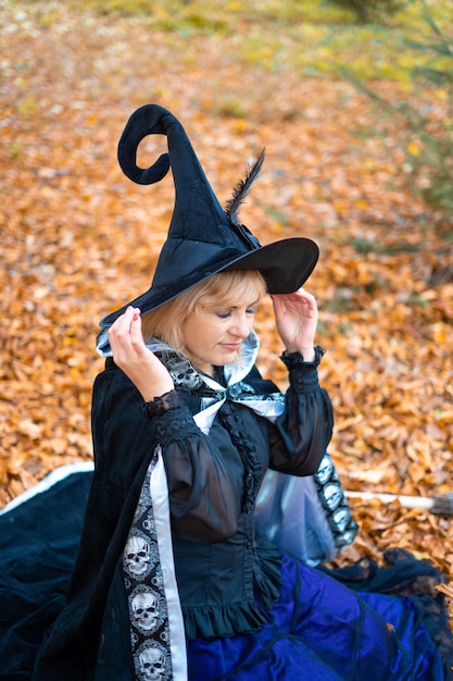 Photo a woman in a witch suit in a dense forest on a ritual