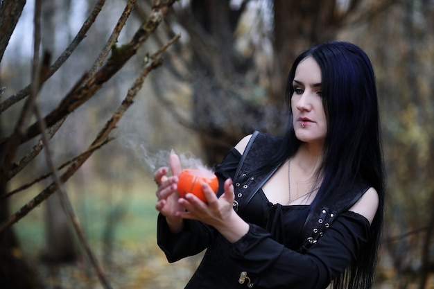 A woman in a witch suit in a dense forest on a ritual