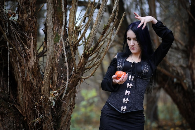 Photo a woman in a witch suit in a dense forest on a ritual