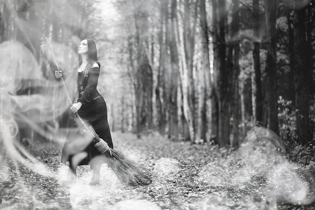 A woman in a witch suit in a dense forest on a ritual