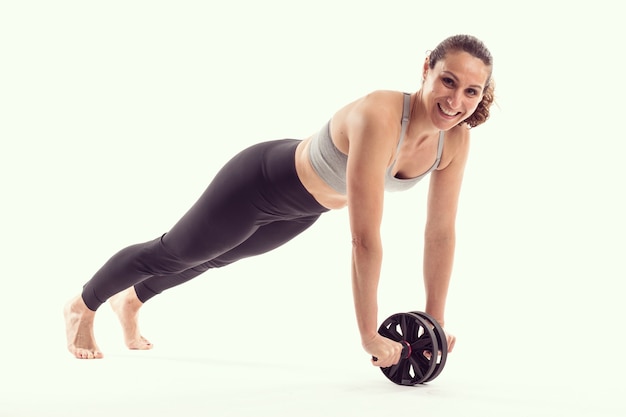 Woman with abdominal wheel stretching body