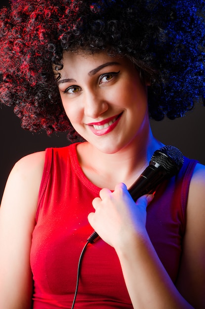 Woman with afro hairstyle singing in karaoke