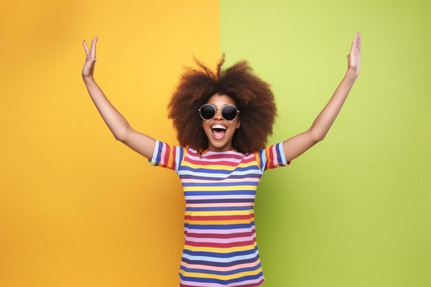 A woman with an afro wearing sunglasses and a colorful striped top with her arms up