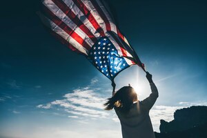 Женщина с американским флагом на пляже. 4 июля. день независимости. патриотический праздник.