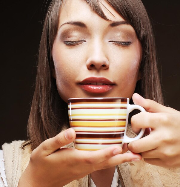 写真 香り豊かなコーヒーを持つ女性