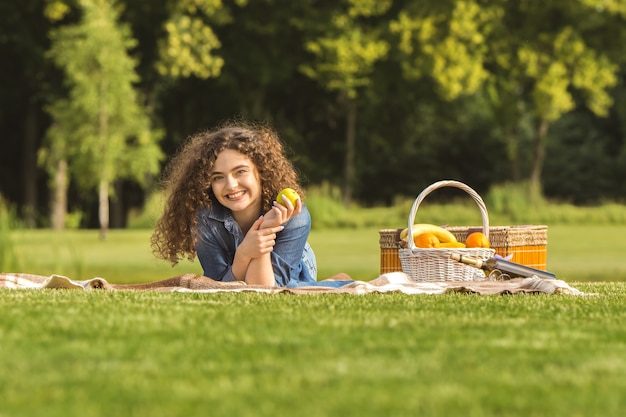 The woman with an apple lay on the grass