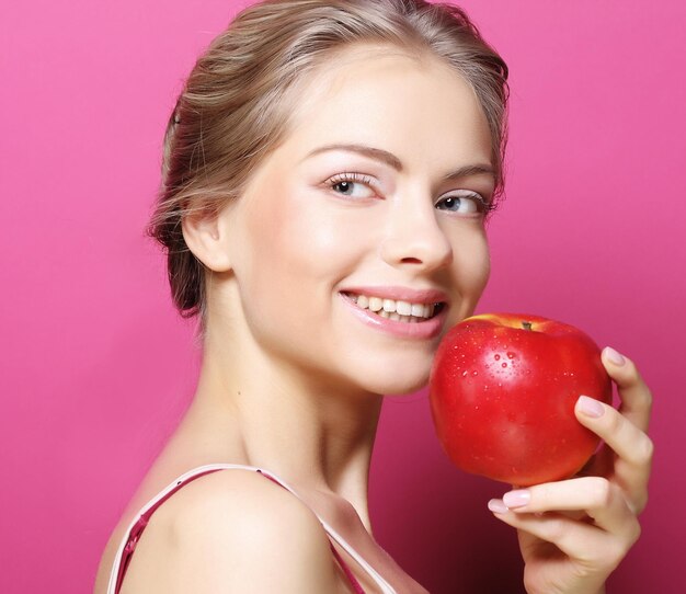 Photo woman with apple over pink background