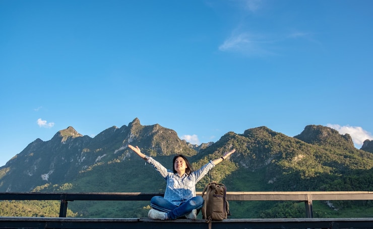 Photo 腕を伸ばした女性が青い空の反対側のレールに座っています