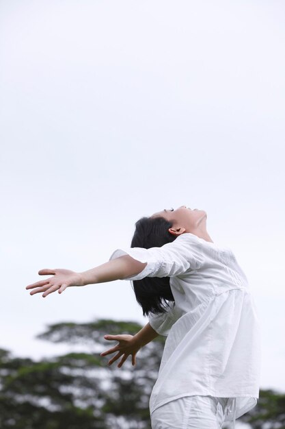 사진 팔을 펴고 하늘을 향해 서 있는 여자