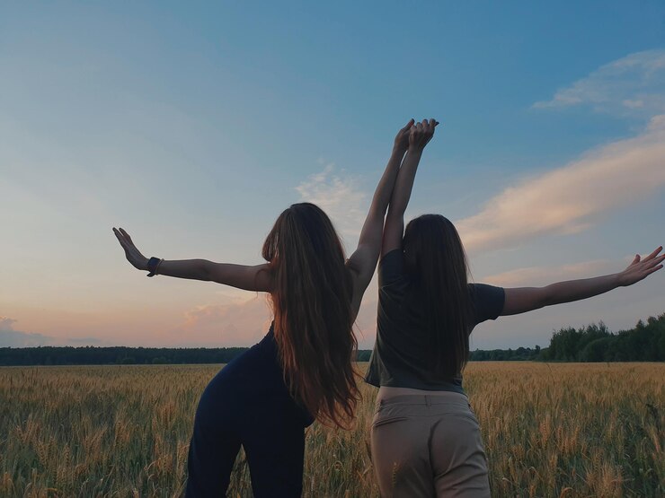 Photo woman with arms outstretched standing on field against sky