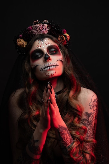 Woman with artistic spooky makeup and fresh flowers on head standing prepared for halloween party