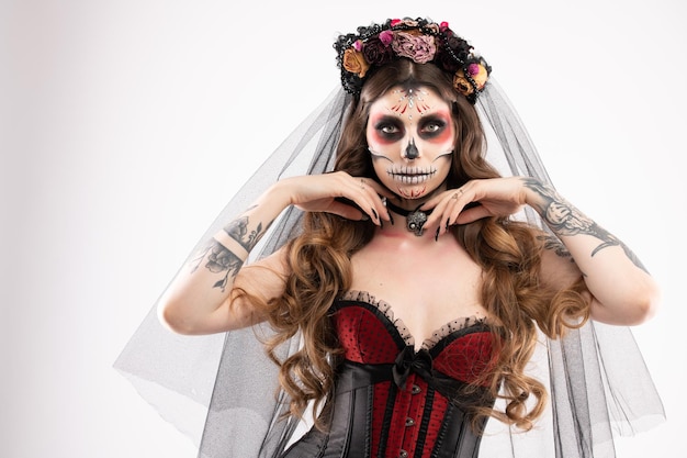 Woman with artistic spooky makeup and fresh flowers on head standing prepared for halloween