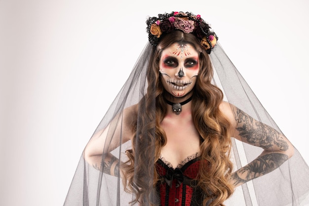 Woman with artistic spooky makeup and fresh flowers on head standing prepared for halloween