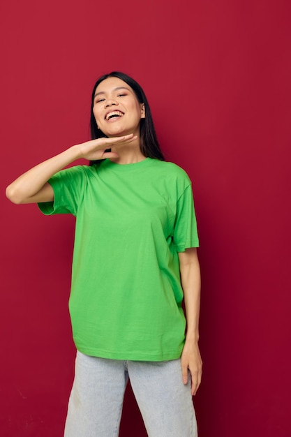 Photo woman with asian appearance green tshirt gestures with his hands isolated background unaltered