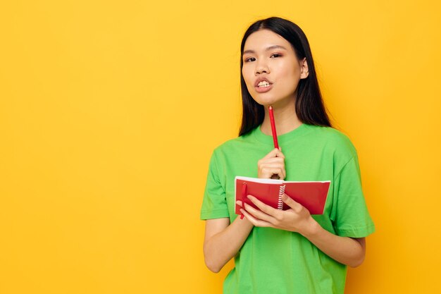 Photo woman with asian appearance notebook and pen learning education isolated background unaltered