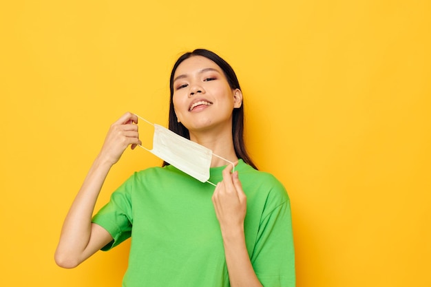 Woman with Asian appearance posing wearing a medical mask safety fun isolated background unaltered