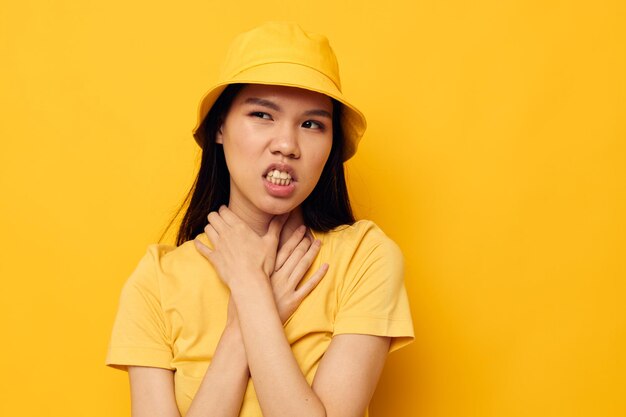 Woman with Asian appearance in a yellow tshirt and hat posing emotions Monochrome shot