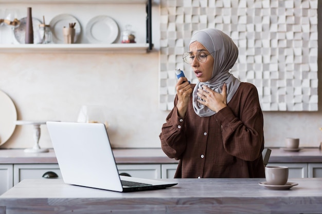 Woman with asthma at home muslim woman in hijab using inhaler to ease breathing housewife working