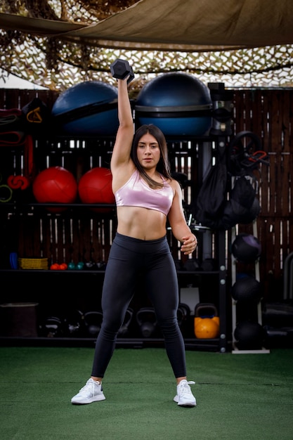 женщина со спортивным телом делает упражнения в тренажерном зале на открытом воздухе