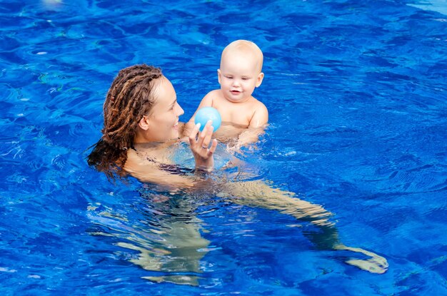 Foto donna con un bambino che nuota in piscina