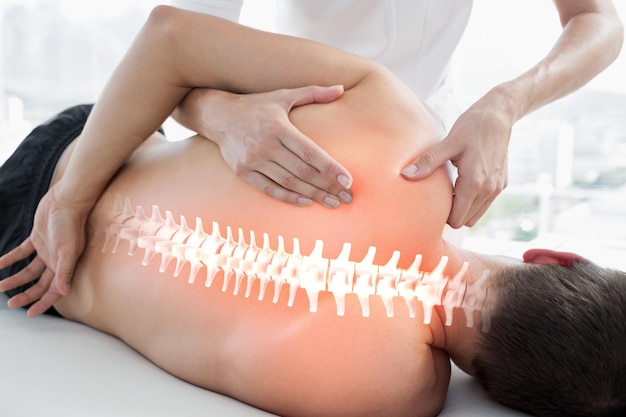 a woman with a back pain is touching the back of her back